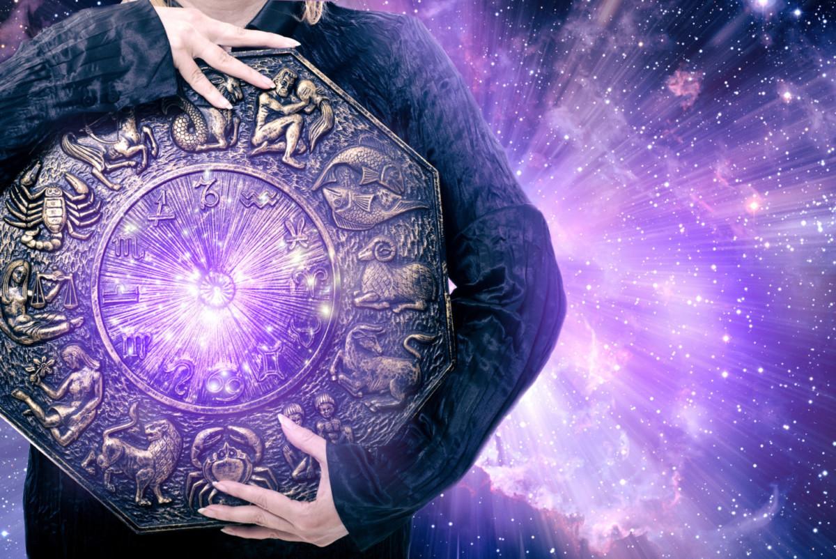 o que é mapa astral mulher segurando tábua de zodíaco na galáxia