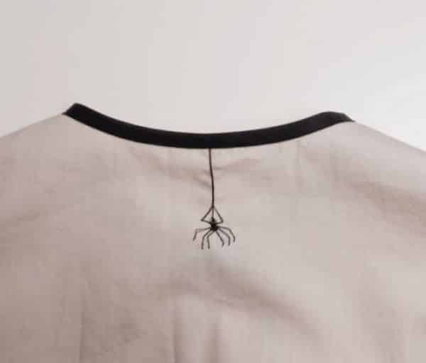 bordado feito no decote na parte de tras da camiseta com desenho de uma aranha
