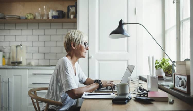 Side view of designer using laptop at home office