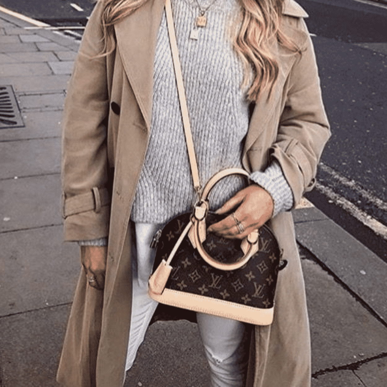 Mulher segurando bolsa Alma da Louis Vuitton