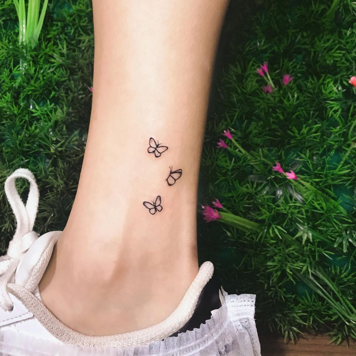 tatuagem de três borboletas pequenas no tornozelo