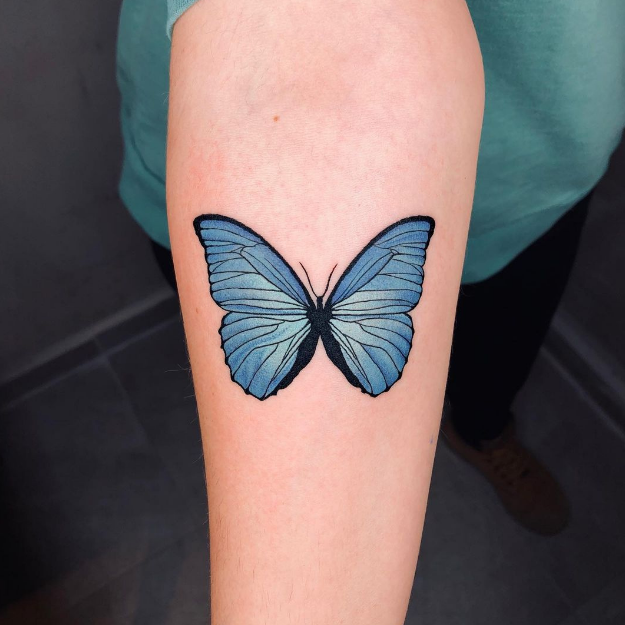 tatuagem de borboleta azul no braço
